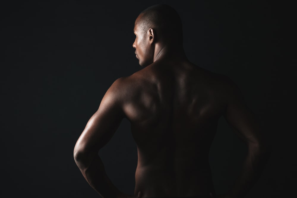 Young sports man, standing back, looking aside