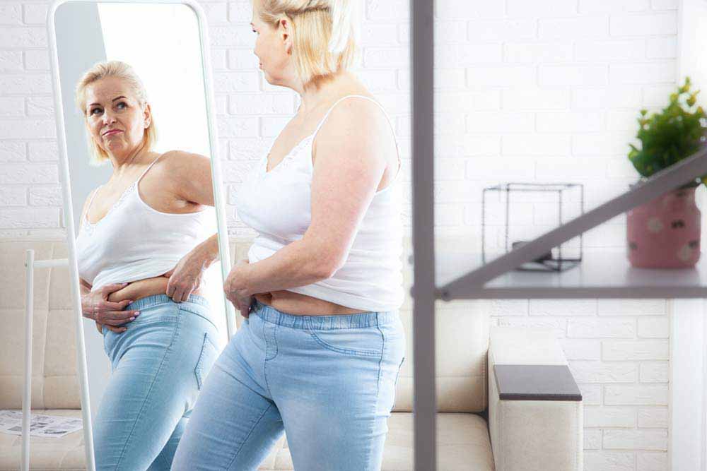 middle-aged woman looking at herself in the mirror