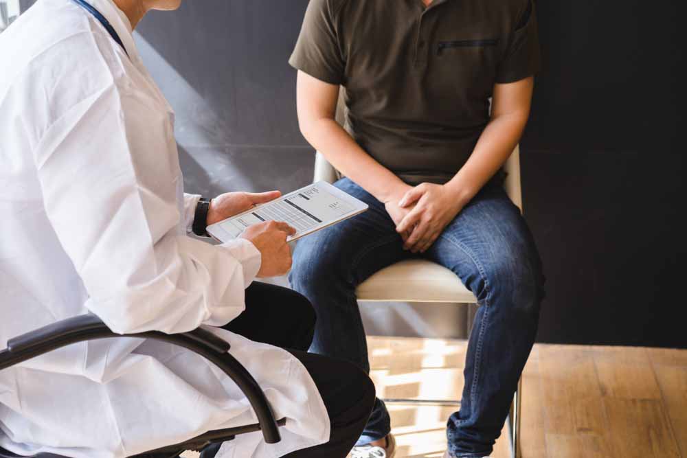 Male doctor and patient are discussing about test report