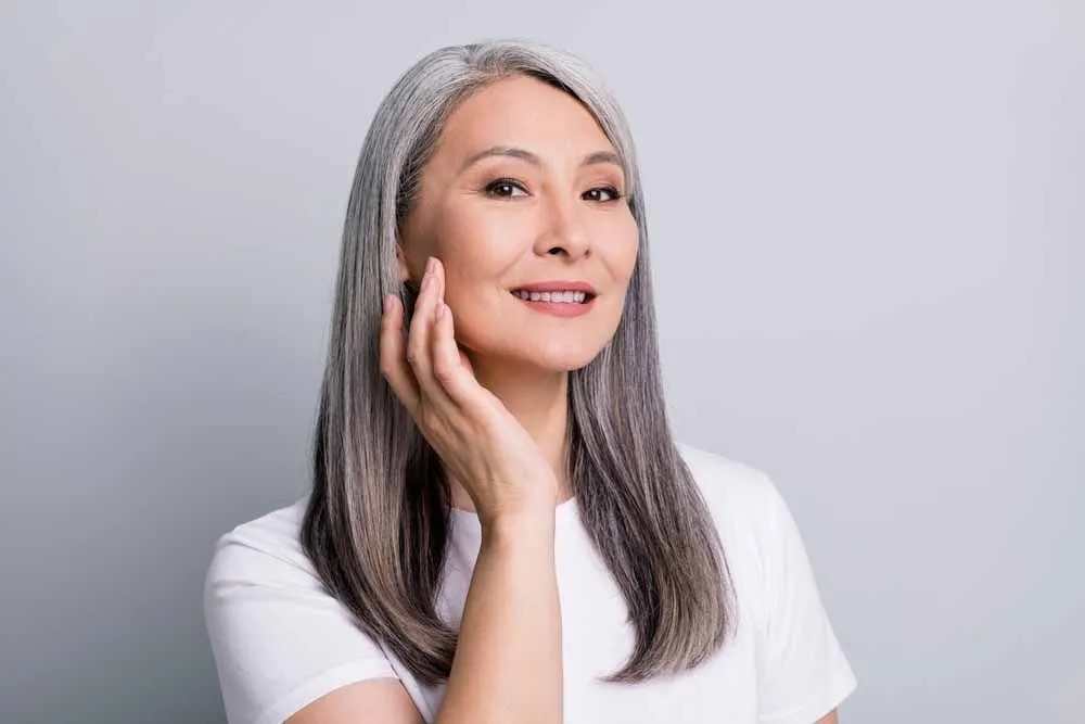 Woman smiling and touching cheek gently