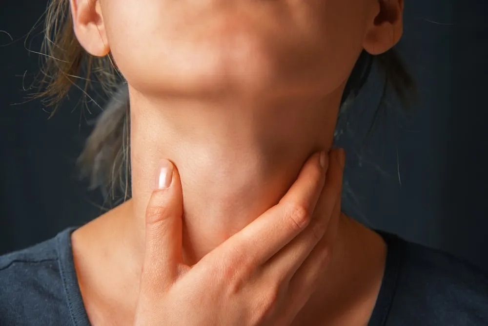 Woman touching neck